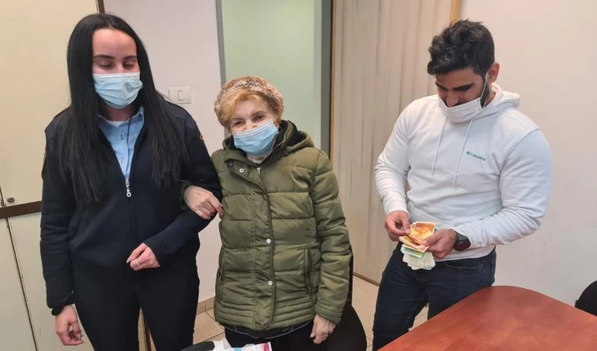 הכסף מוחזר לניצולת השואה בתחנת המשטרה בעכו (צילום: דוברות המשטרה)