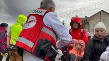 שמעון סבג מעמותת "יד עזר לחבר" מחלק מזון ושתייה לפליטים (צילום: מירב בן שלום)