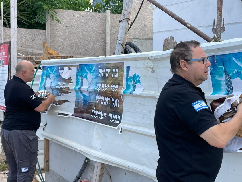 פקחי העירייה מסירים את המודעות (צילום: ראובן כהן, דוברות עיריית חיפה)