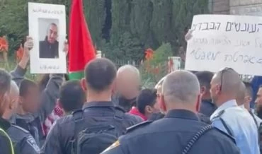 הנפת דגל פלסטין בהפגנה (צילום: דוברות המשטרה)
